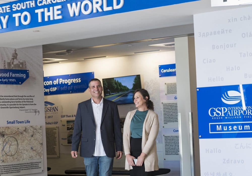Smiling man and woman standing in front of the GSP airport museum.