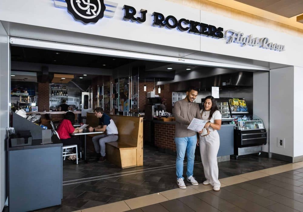 Image of a couple looking at a menu outside of the RJ Rockers Flight Room.