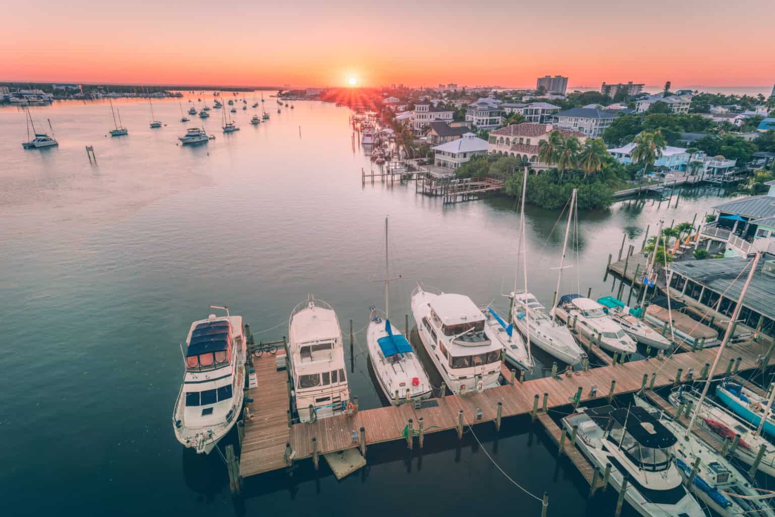 Sunset at Fort Myers marina with several boats in the water and docked.